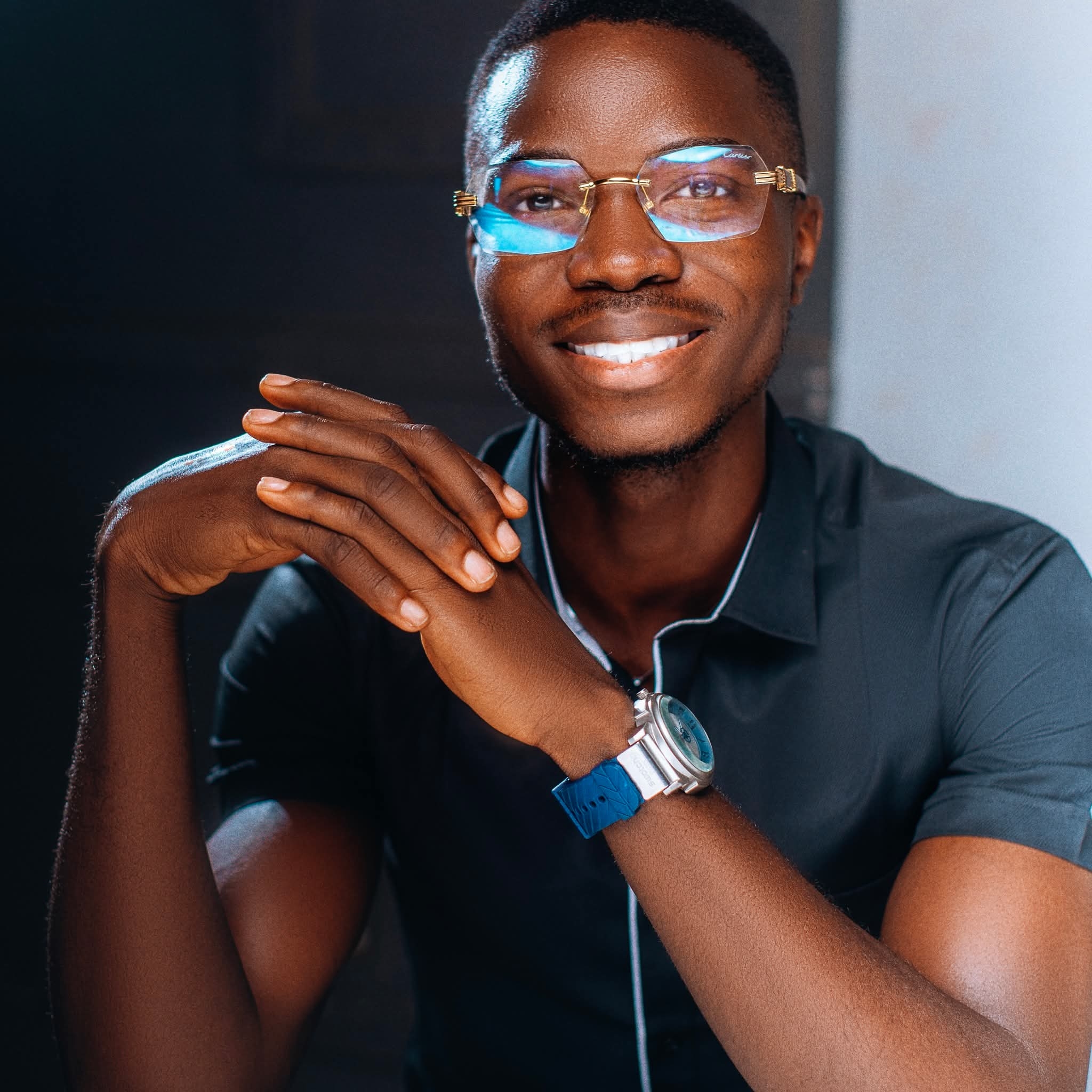 Abraham Adesanya, Nigerian sewing machine specialist and author, standing beside a well-maintained black head treadle sewing machine. Warm, relaxed, confident expression.