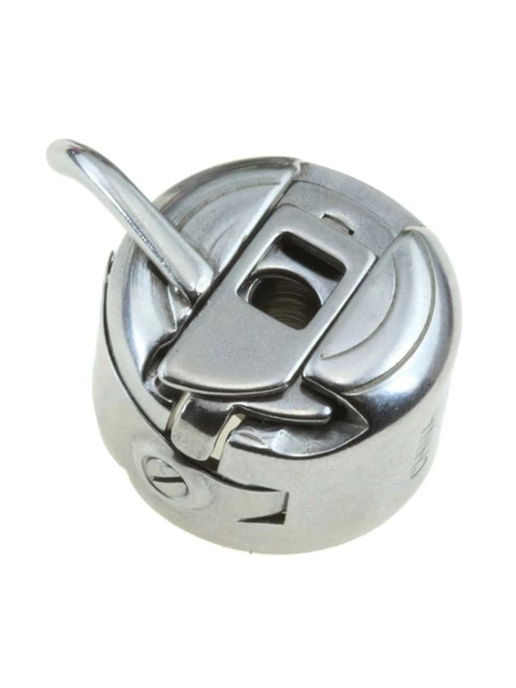 Close-up photograph of a sewing machine bobbin case showing the housing and tension spring