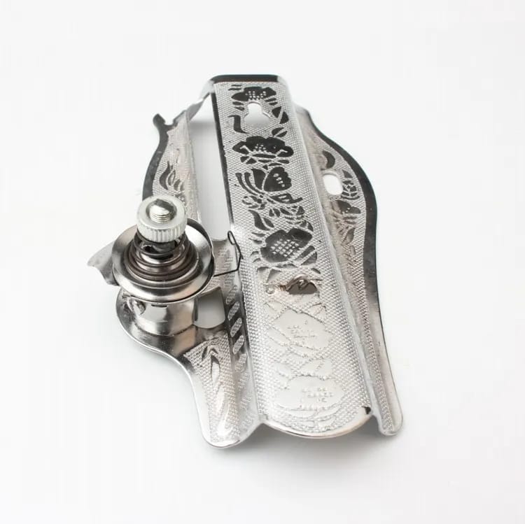 Photograph of a sewing machine face plate — the removable panel on the left side of the machine head