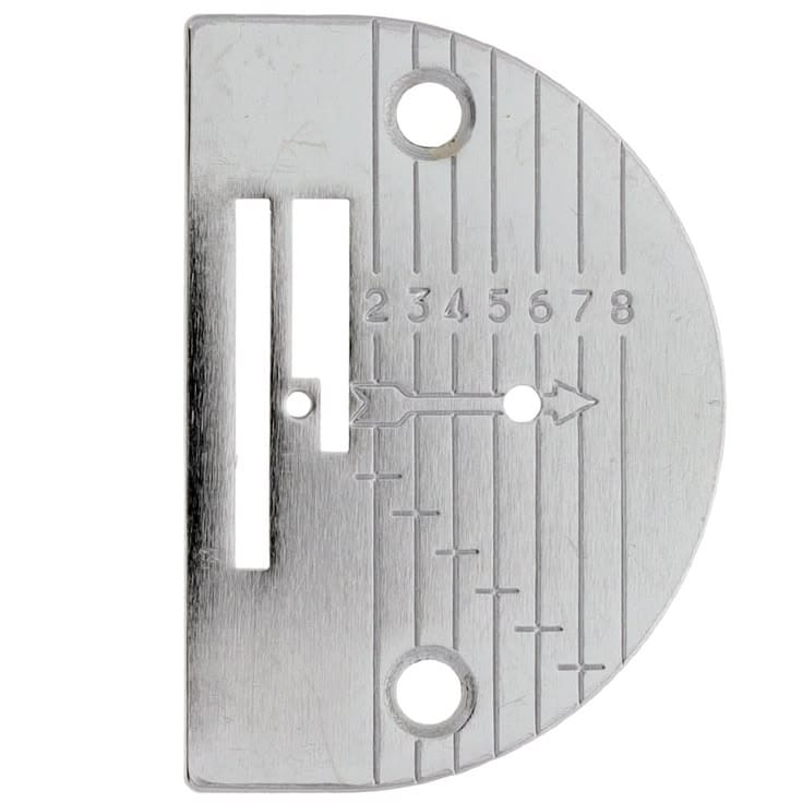 Close-up photograph of a sewing machine needle plate — the flat metal plate beneath the needle with a hole for needle passage