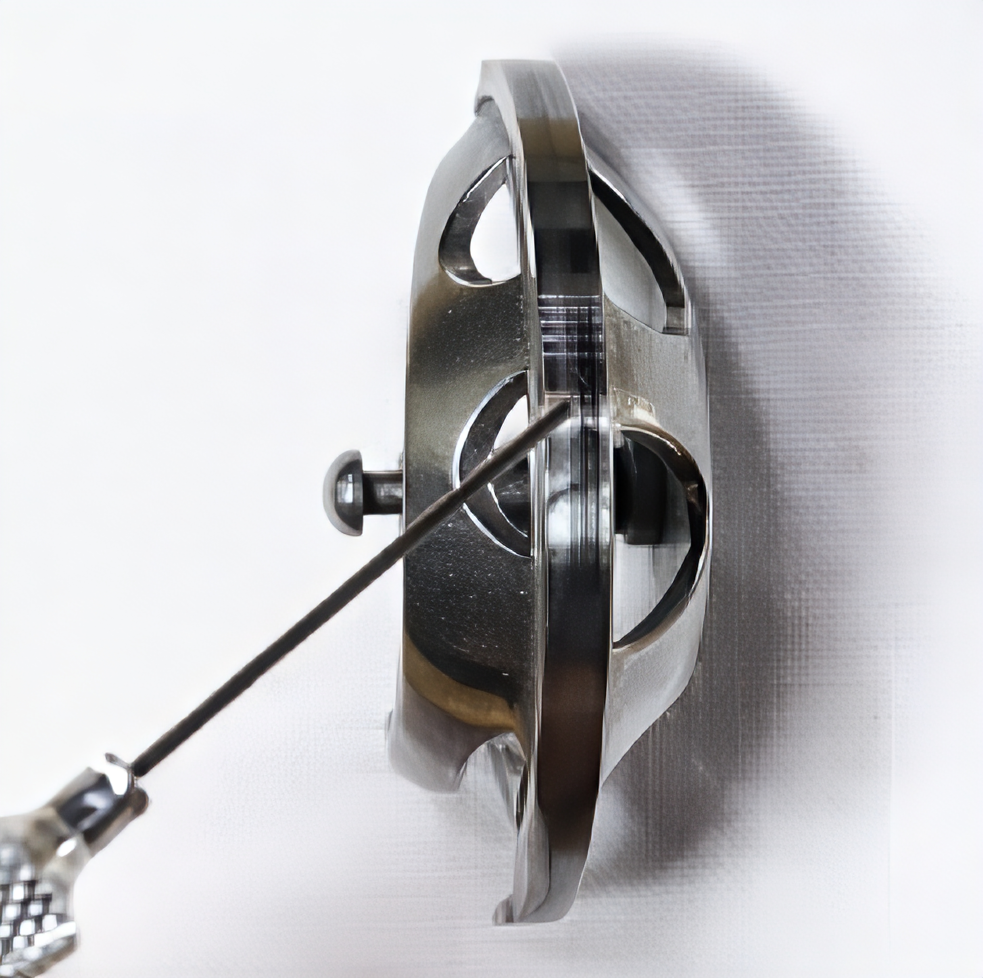 A small bottle of clear sewing machine oil held above the hook race of a black head treadle sewing machine, with a single drop of oil being applied to the oiling point
